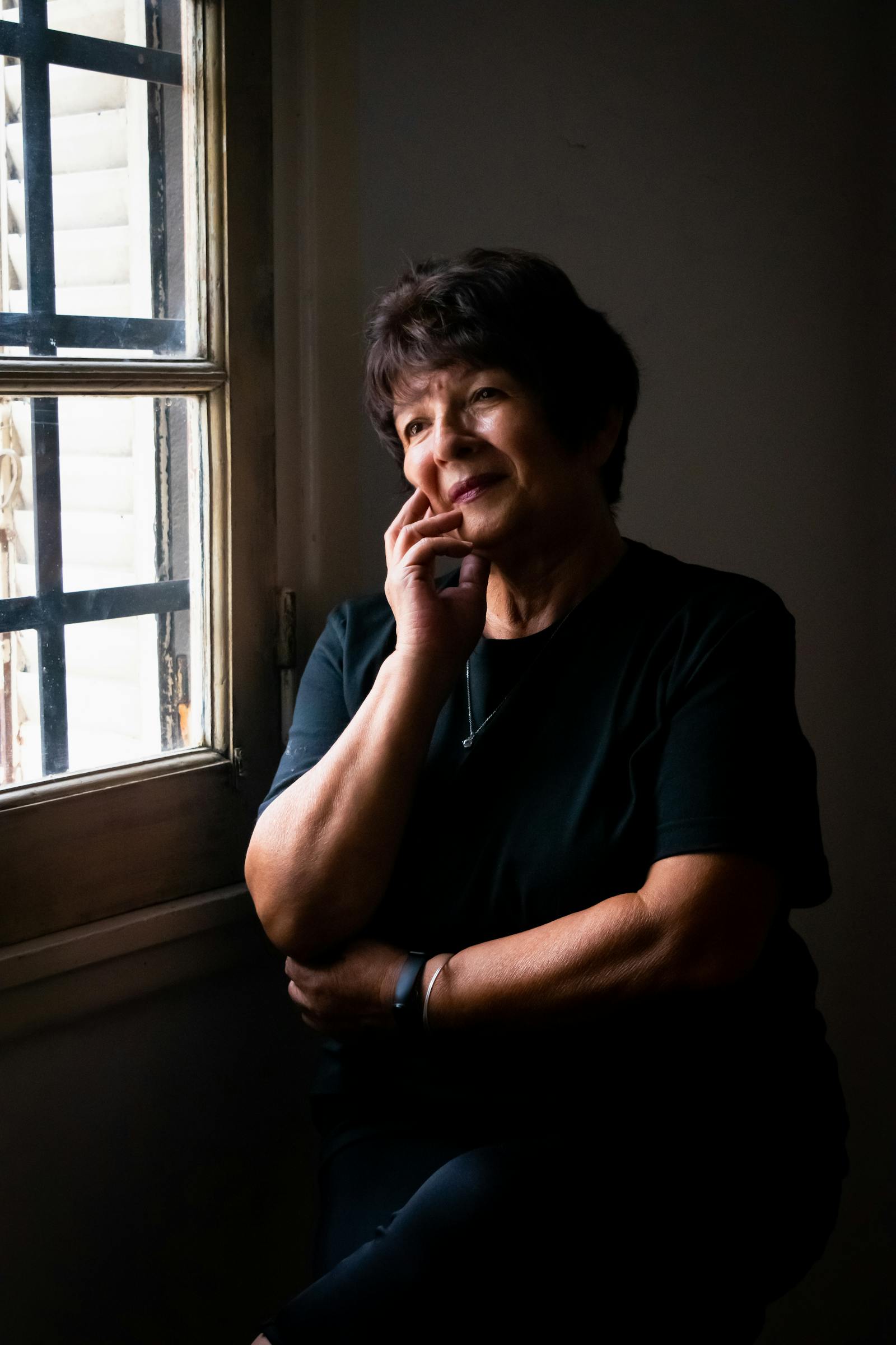 Mujer pensativa junto a una ventana en gesto reflexivo — espiritualidad auténtica