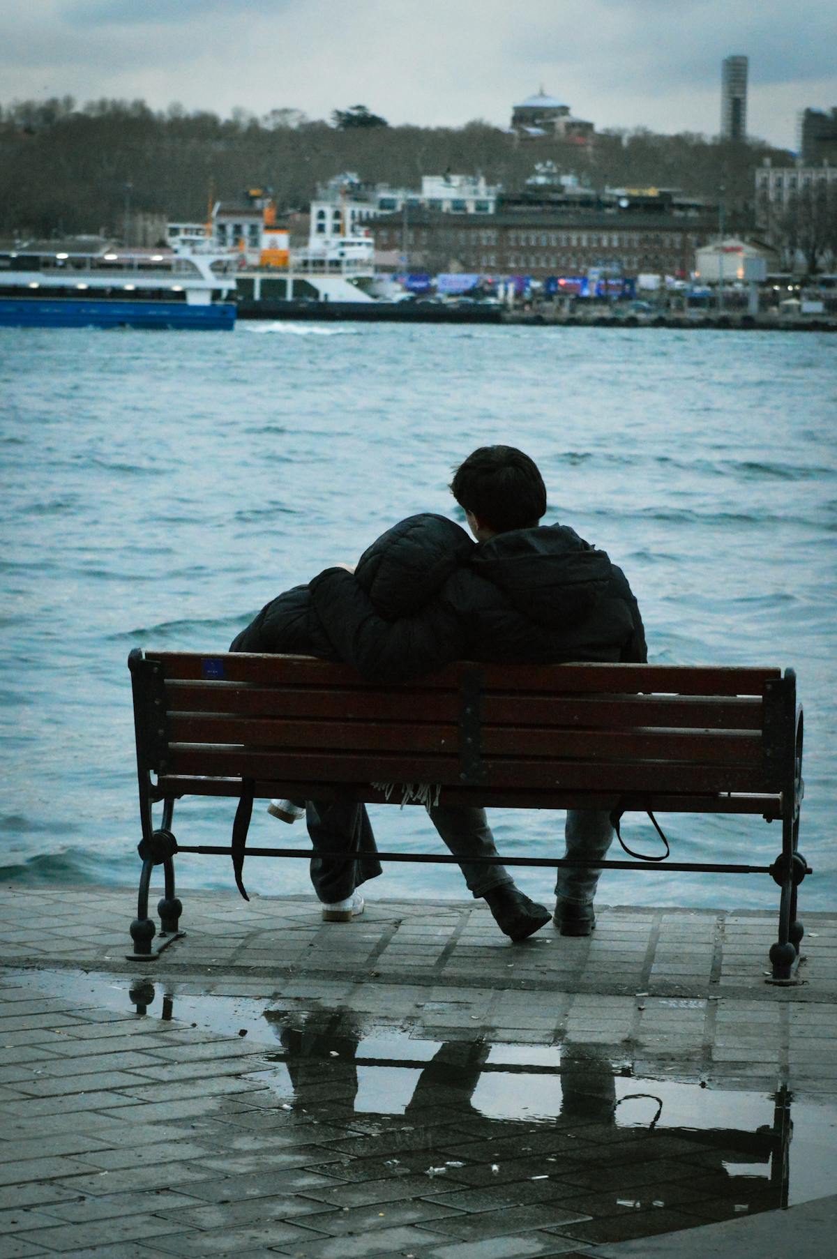 Pareja sentada frente al mar reflexionando sobre la relación